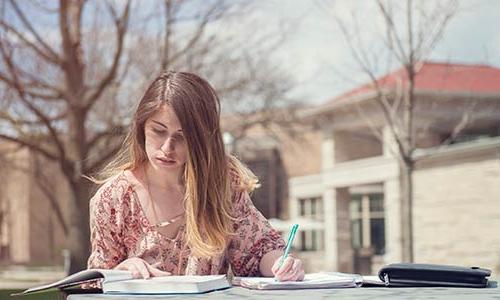 Girl studying at picnic table outside